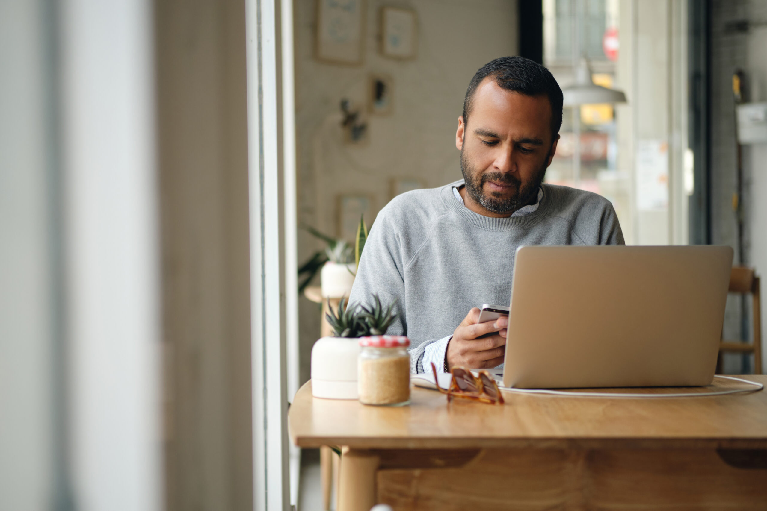 Entrepreneur travaillant sur son ordinateur portable et son téléphone dans un café